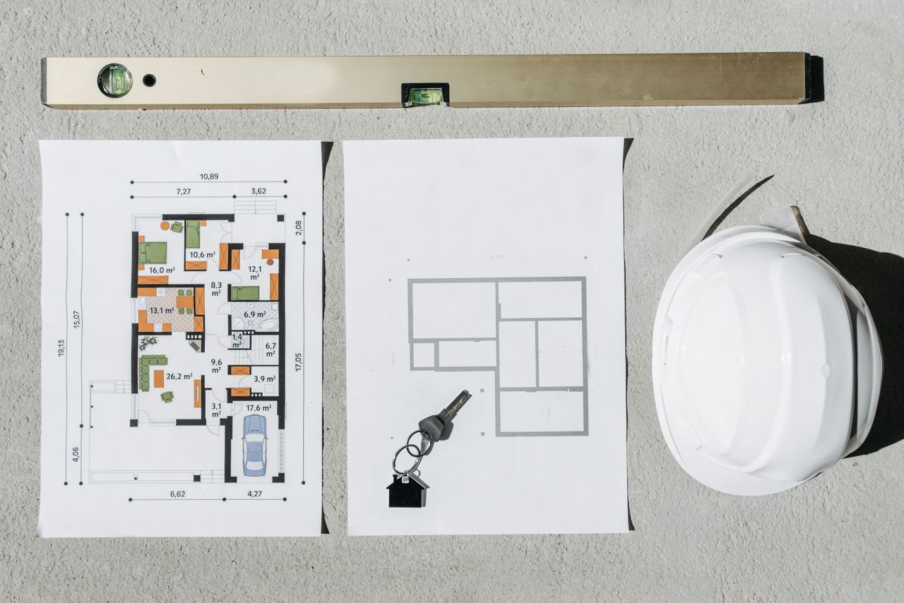 gallery-3 Blueprints, spirit level, and hard hat symbolize house planning.