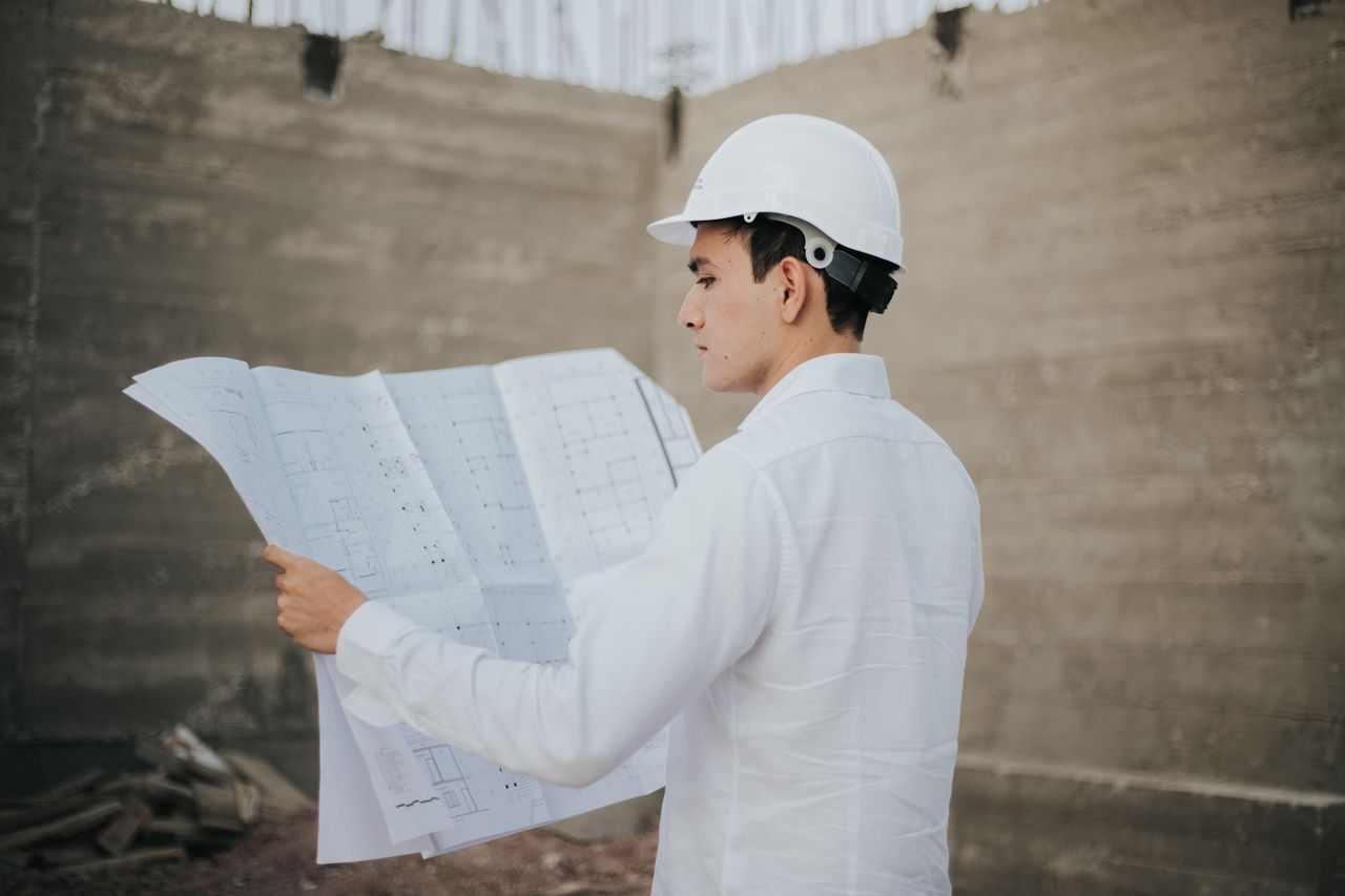 hero-img-01 Architect examining blueprints at a construction site in Mexico.
